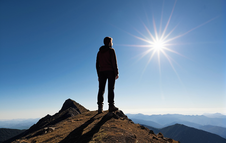 A serene and expansive wide-angle photograph capturing an individual, possibly a silhouette, standing on a mountain ridge or peak, gazing out at a majestic, tranquil mountain panorama under a clear, bright sky. The image should convey a profound sense of peace, mental clarity, and relief from stress, embodying the therapeutic effect of nature and the absence of digital distractions.
